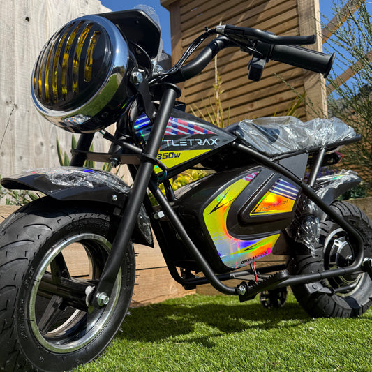 Small electric bike with colorful design on a wooden deck and grass background